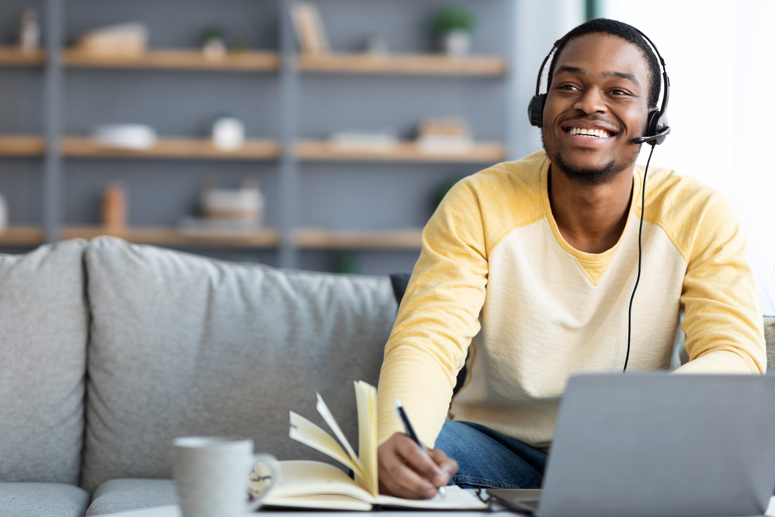 Joyful black guy having online class at home